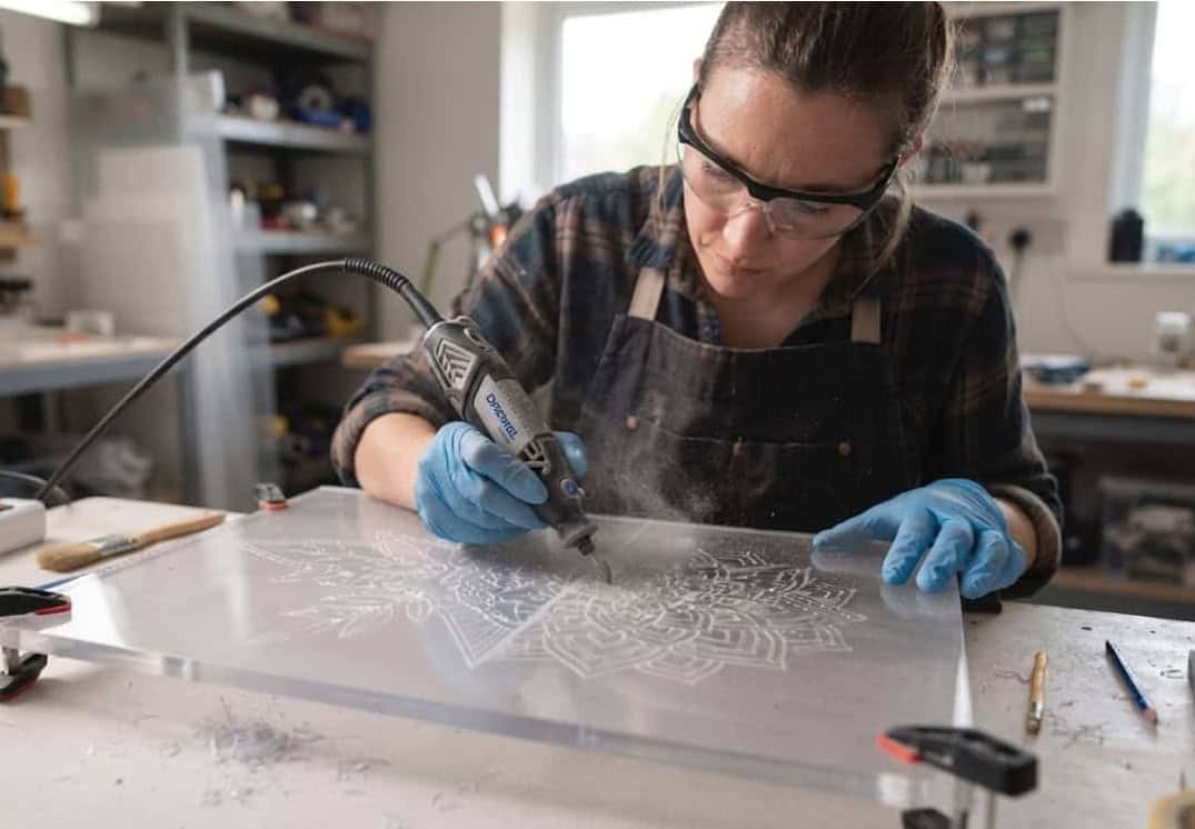 Eine Person graviert eine Polycarbonatplatte mit einem Multischleifer.